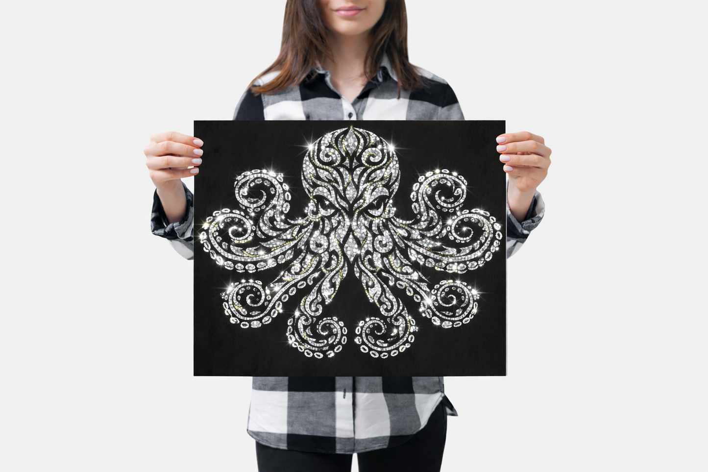 Person holding AI generated completed Thalor the Octopus rhinestone canvas showing finished black and white octopus design sparkling with rhinestone crystals across all eight tentacles and sucker detail placement zones